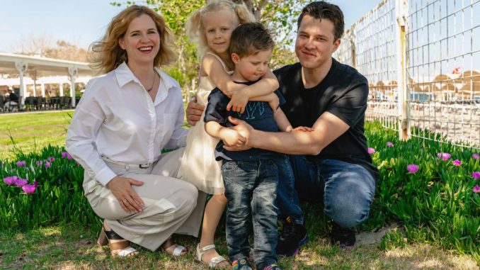 Family of four enjoying a sunny day outdoors in Kemer, smiling and spending quality time together.