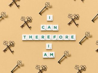 Inspirational phrase made from tiles surrounded by decorative keys on a beige background.