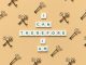 Inspirational phrase made from tiles surrounded by decorative keys on a beige background.